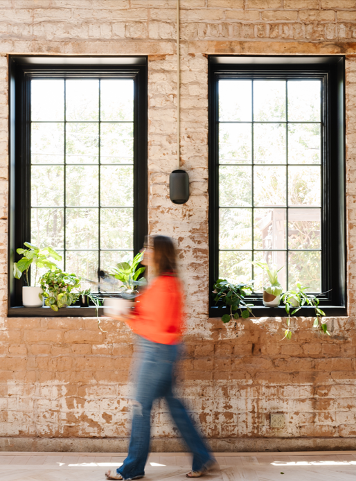 Vintage stone wall with tall black casement windows with grilles